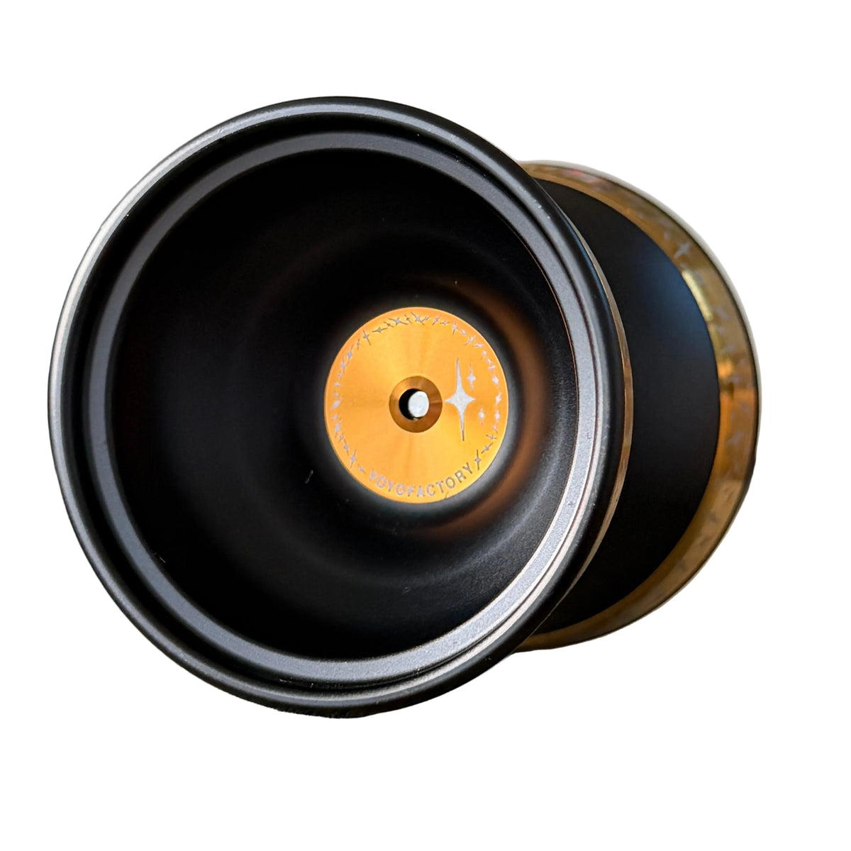 Starlight plus black yo-yo with a metallic gold center label and a bronze-toned outer rim.